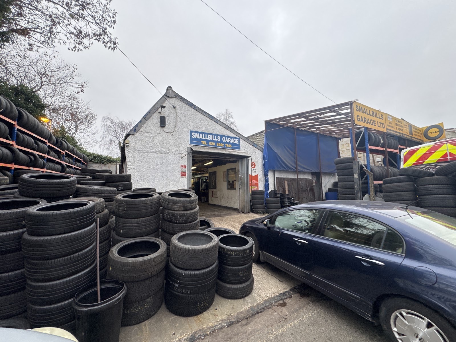 Mechanic working underneath a car on the ramp at Smallbills Garage Ltd & Tyre shop